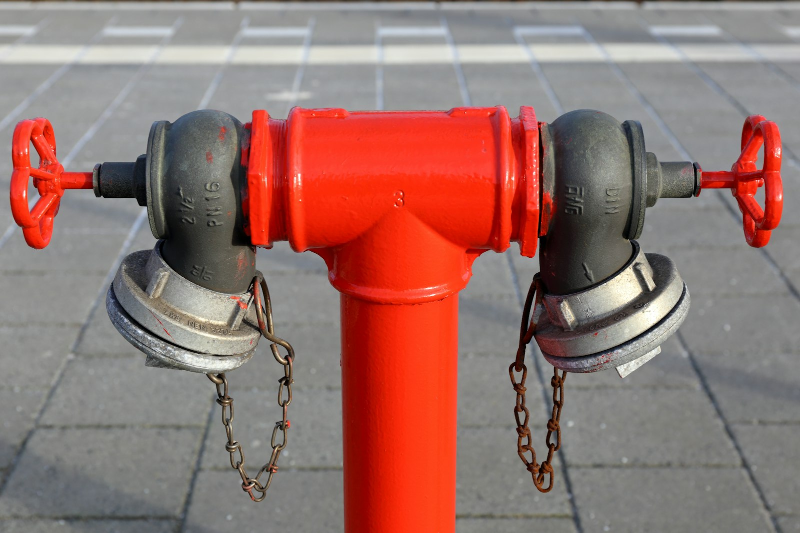 Red fire hydrant on a sidewalk beside a quiet residential street
